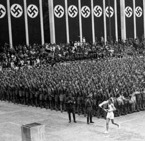 Olympisk massemønstring: fakkelen kjem til Olympiastadion i Berlin, 1936. 